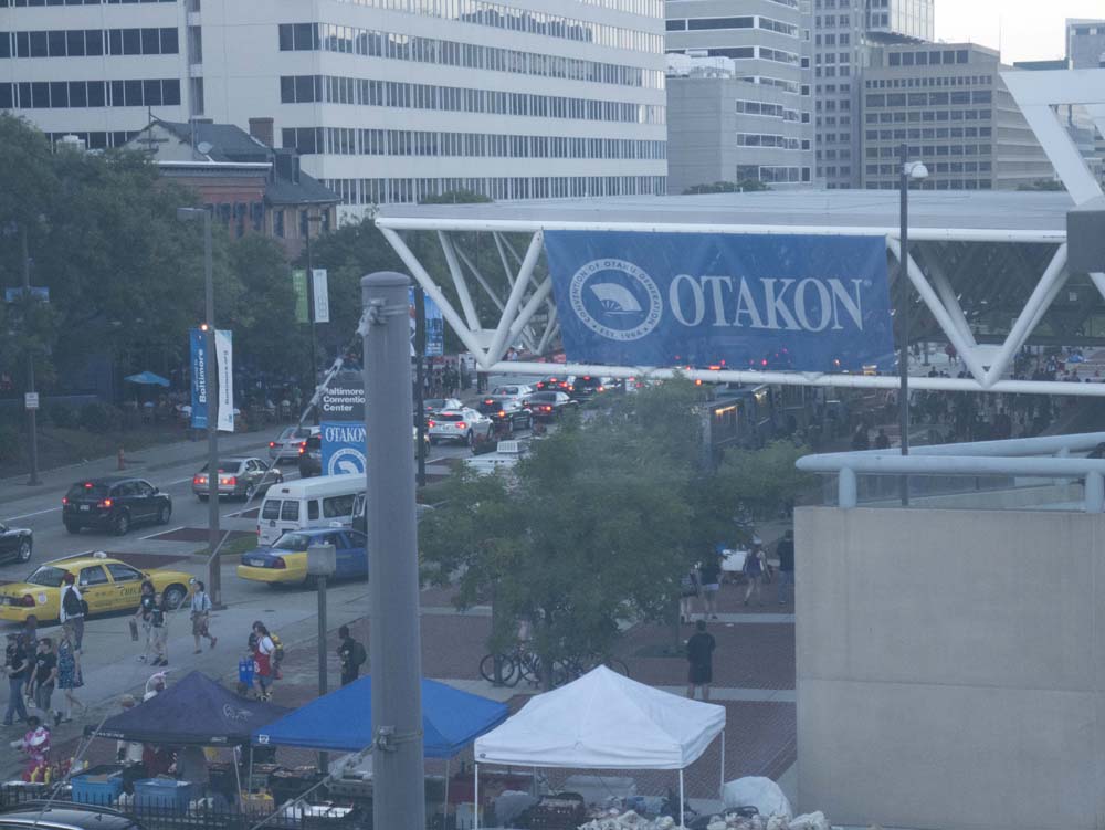 A view of the Baltimore Convention Center, with a giant Otakon banner hung from the roof. Farewell, Baltimore Convention Center.