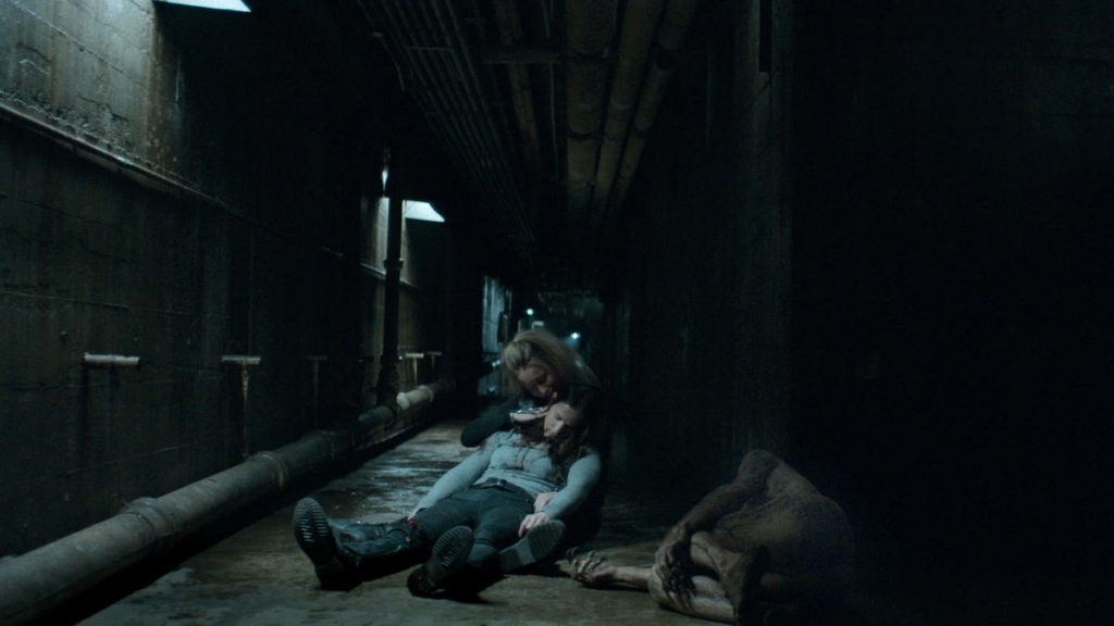 Susan (Hilary Jardine) comforts an injured and collapsed Vanessa (Kelly Overton)